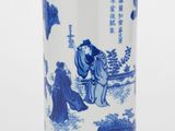 un vase bleu et blanc sur lequel est représenté un homme et une femme