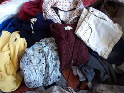 une pile de vêtements posée sur un lit