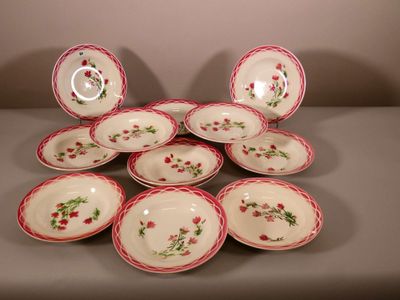 six assiettes rouges et blanches ornées de fleurs, posées sur une table