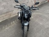 une moto noire garée devant un mur de briques