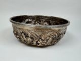 a silver bowl on a white table with a white background
