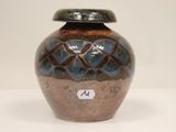 a brown and blue vase sitting on a white table