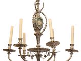 un lustre sur lequel sont disposées cinq bougies et une horloge