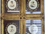 quatre portraits de femmes dans des cadres dorés richement décorés, accrochés au mur