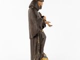 a wooden statue of a man with a feather on his head