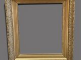 a gold frame with a decorative pattern on a gray background