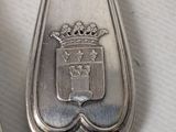 a silver spoon with a crown on it sitting on a table