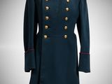 a blue military coat with gold buttons on a mannequin stand