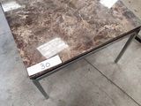 une table en marbre sur laquelle est posée une étiquette de prix, dans un magasin