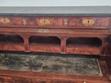 a wooden desk with a marble top and drawers