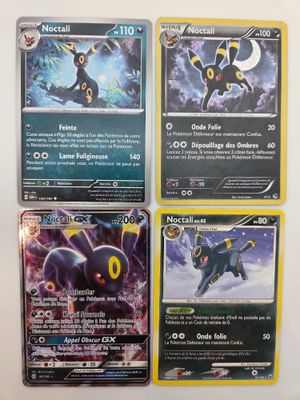 Quatre cartes Pokémon sont posées sur une table avec un fond blanc.