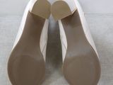 pair of women ' s white shoes on a white surface