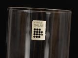 a glass with a button on it sitting on a table