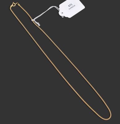 un collier en or composé d'une chaîne et d'un pendentif, sur fond noir