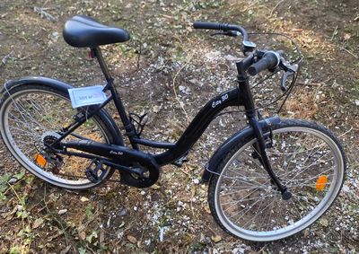 a black bicycle that is parked in the grass