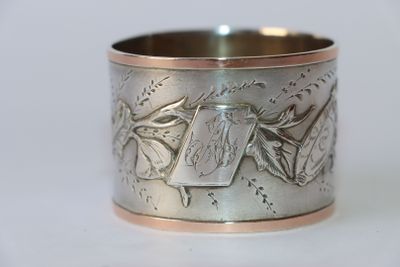 une image montrant un gros plan d'une bague en argent posée sur une surface blanche