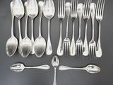 a lot of silver spoons and forks on the table