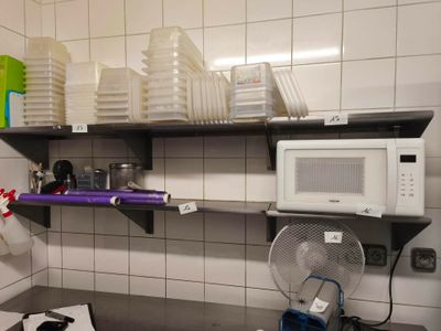 a microwave and a fan in a small kitchen