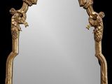 un miroir orné d'un cadre doré sur lequel sont représentés des oiseaux