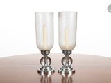 two wine glasses sitting on a table with a candle