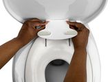 a person that is holding the lid of a toilet