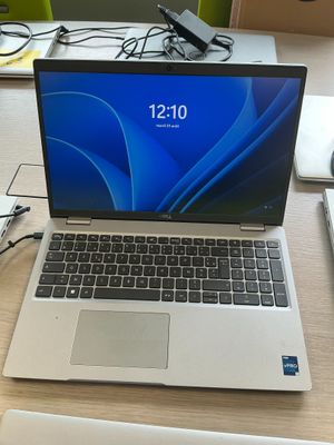 a laptop computer sitting on a desk with a charger