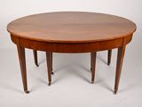 an oval dining table with four legs and a wooden top