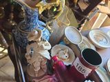 un plateau avec des assiettes, des tasses et des vases posé sur une table