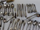 many spoons and forks laid out on the table