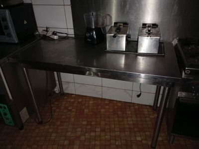 une cuisine équipée d'une cuisinière, d'un évier, d'un micro-ondes et d'un grille-pain posés sur le plan de travail