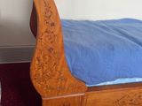 a wooden bed with a blue comforter in a room