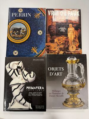 trois livres posés sur une table sur laquelle se trouve un vase