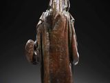 a bronze figure of a man with a hat and robe