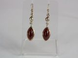 a pair of silver and red stone earrings on a clear display