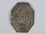 a silver coin with a castle on it on a white surface