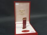 une petite boîte rouge contenant un flacon de parfum