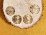 four coins sitting on top of a piece of wood