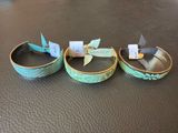three rings that are sitting on a leather surface