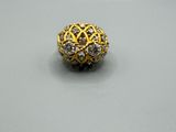 gros plan d'une bague en or et diamants sur une surface blanche