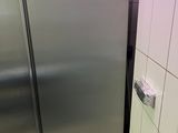 un réfrigérateur en acier inoxydable dans un coin de la salle de bains