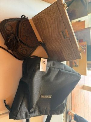 deux sacs et un sac à main posés côte à côte sur une étagère
