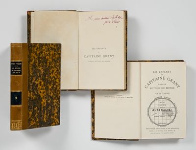 trois livres sont empilés sur une surface blanche