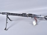 an old machine gun on a tripod stand on a white surface