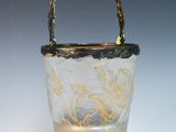 a small glass bucket with a handle on a table
