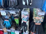 many pairs of gardening gloves on display in a store