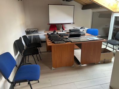 une salle équipée d'un bureau, de chaises et d'un écran de projection