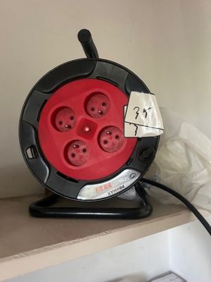 une image représentant un cordon électrique rouge et noir branché sur une prise murale