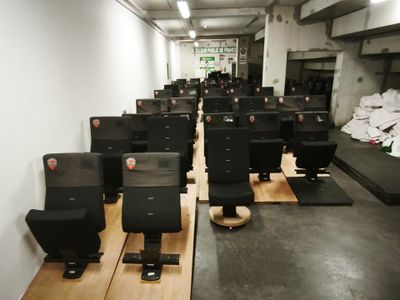 des rangées d'écrans d'ordinateur posés sur des palettes en bois dans une pièce