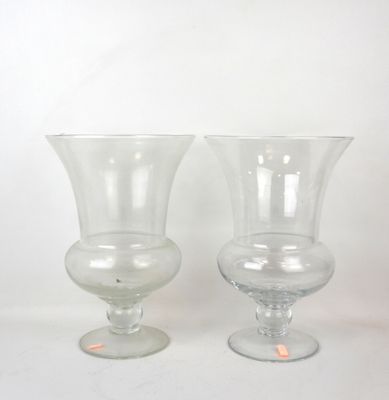 two clear glass vases sitting on a white surface