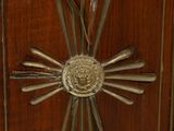 a wooden cabinet with a metal sunburst on it